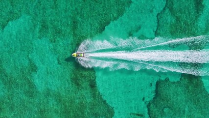 Aerial footage captures a jet ski gliding over Cozumels clear turquoise waters, showcasing the vibrant marine life beneath, inviting viewers to explore this tropical paradise and its natural beauty - Powered by Adobe