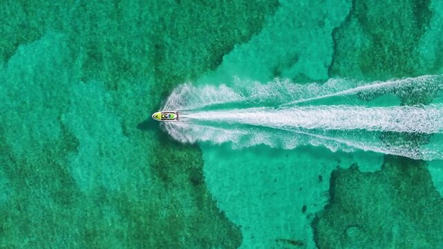 Aerial footage captures a jet ski gliding over Cozumels clear turquoise waters, showcasing the vibrant marine life beneath, inviting viewers to explore this tropical paradise and its natural beauty