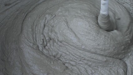 Mix plaster adhesive in black bucket for wall tiling. Get ready to fix those tiles. Home improvement project, aimed at making home repairs easy, efficient, aesthetically pleasing. Electric mixer