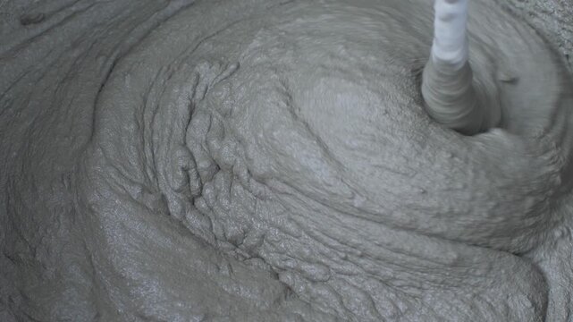 Mix plaster adhesive in black bucket for wall tiling. Get ready to fix those tiles. Home improvement project, aimed at making home repairs easy, efficient, aesthetically pleasing. Electric mixer