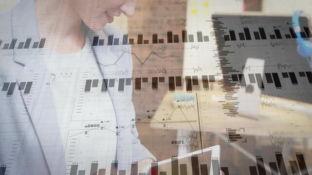 Woman tapping tablet screen in modern office, generating animated finance charts for data tracking