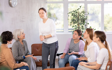 Female colleagues sit in semicircle during meeting and discuss plans to resolve situation.active...