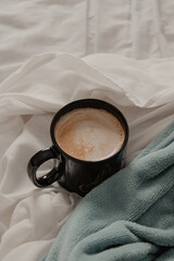 Coffee Cup on Bed with Blue Blanket
