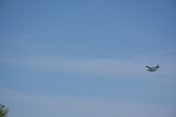 A show plane flies in the distance across the blue sky
