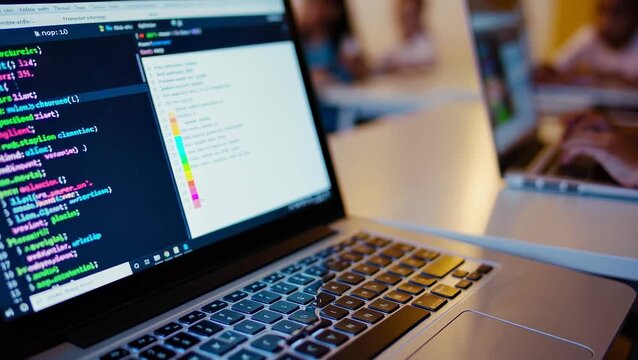 Laptops Displaying Code and Charts in Classroom Setting                                                     