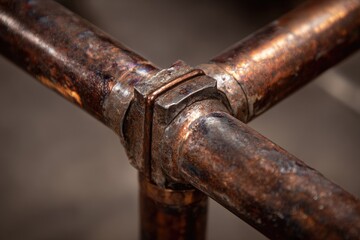 Aged copper pipe joint close-up