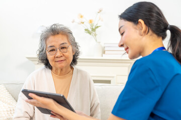Doctor examine and advice medical treatment plan on digital tablet to senior woman patient. Nurse...