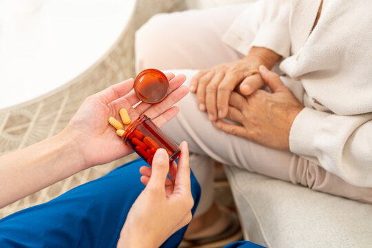 Female doctor explaining medication to senior woman patient at home. Nurse or caregiver take care and consult elderly woman at nursing home. Medical health, drug and medicine and healthcare services.