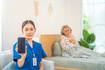 Female caregiver holding mobile phone, showing device screen with senior woman patient suffering...