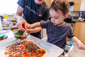 Mother and Boy Toddler Making a Homemade Pizza Together in the Kitchen