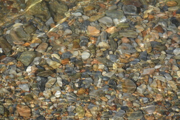 Sea pebbles under transparent sea water. Background