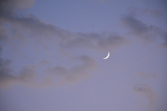 A young new moon in the evening clouds - Powered by Adobe