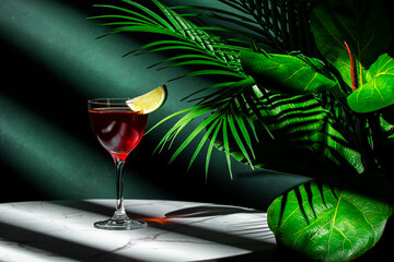 Red alcoholic cocktail drink with whiskey, french brandy, juice, grenadine and lime slice