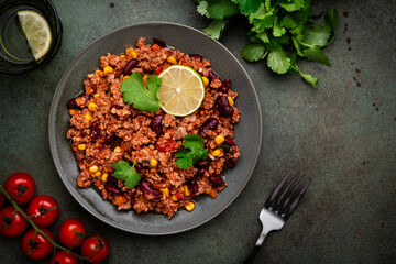 Mexican Chili dish with minced beef, beans, paprika, corn, cilantro, jalapeno pepper in tomato sauce, top view
