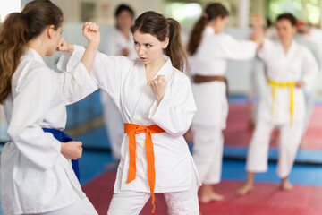 European women in sparring practice punches and blocks during self-defense training