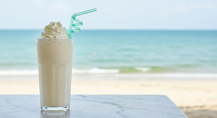 Smoothie with whipped cream  green straw on marble table beach backdrop