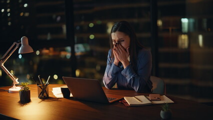 Desperate manager reading dismissal notice at night workplace. Stressed woman
