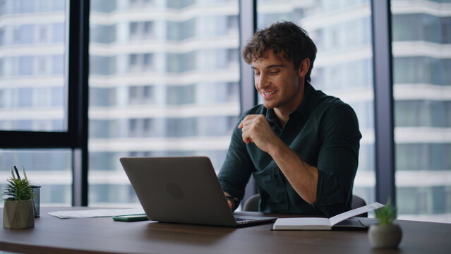 Creative startuper working online at laptop drinking coffee in workplace closeup