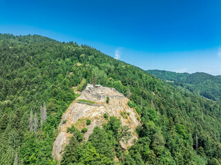 Aerial view of partially restored medieval Rocafort castle in Savoy France on a hilltop with blue sky