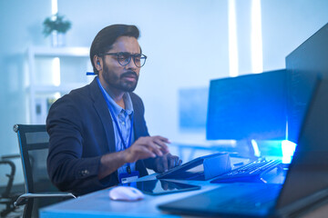 Diverse team of AI developers collaborating in a modern office. Indian male leading a discussion...