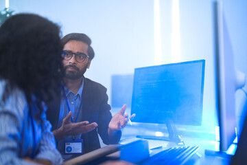 Diverse AI tech team reviewing code for a machine learning algorithm. Indian male and Hispanic...