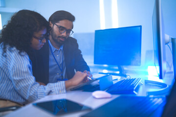Diverse team of AI developers collaborating in a modern office. Indian male leading a discussion...