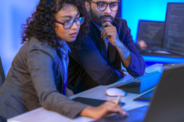 Diverse team of AI developers collaborating in a modern office. Indian male leading a discussion...