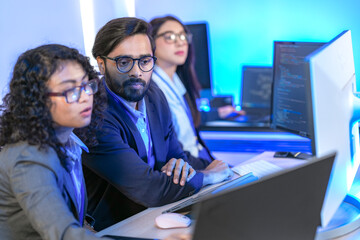 Diverse team of AI developers collaborating in a modern office. Indian male leading a discussion...