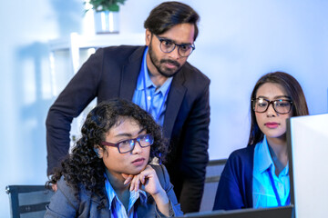 Diverse team of AI developers collaborating in a modern office. Indian male leading a discussion...