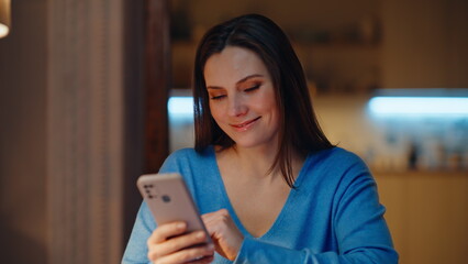 Happy freelancer receiving cellphone message in dark home room closeup. 
