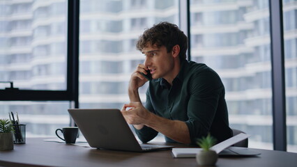 Worried executive talking cellphone discussing document mistake in modern office