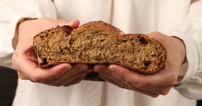 Woman squishing piece of fresh bread, closeup