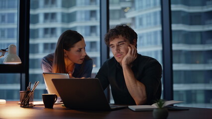 Fototapeta premium Evening colleagues brainstorming project looking laptop closeup. Two coworkers