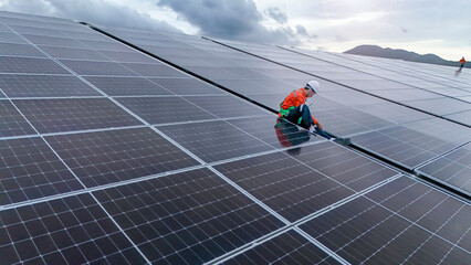 Engineers or technicians in safety gear meticulously inspecting and maintaining large-scale solar...