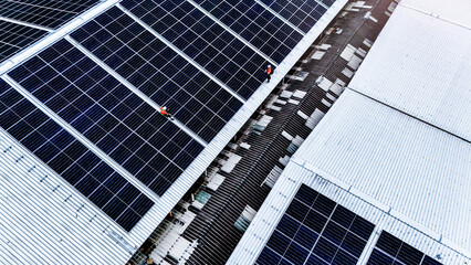technician installs a large photovoltaic system on an industrial rooftop. ESG investment, and the...