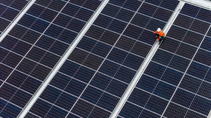 technician installs a large photovoltaic system on an industrial rooftop. ESG investment, and the...