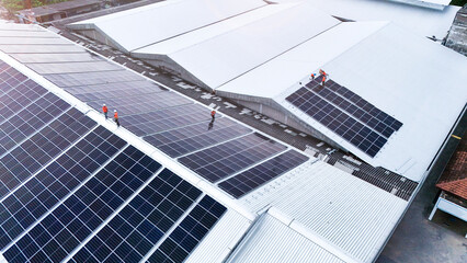 Aerial view of photovoltaic solar panels installed on the metal roof of a commercial building or...