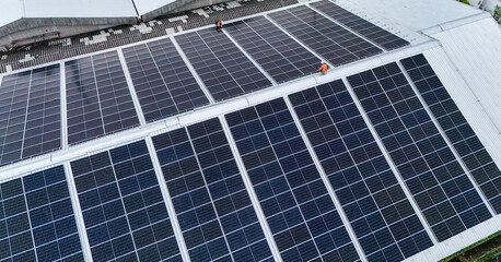 Aerial view of photovoltaic solar panels installed on the metal roof of a commercial building or...
