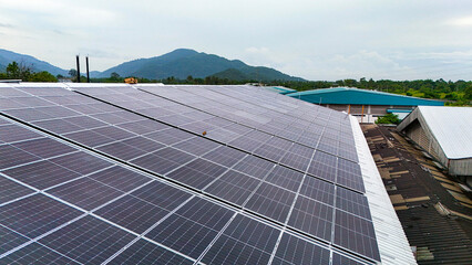 Aerial view of photovoltaic solar panels installed on the metal roof of a commercial building or...
