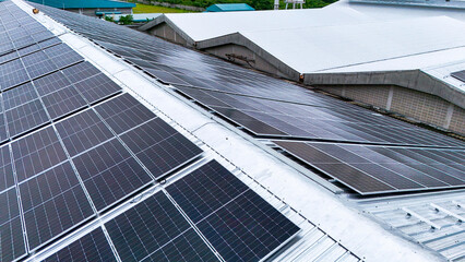 Aerial view of photovoltaic solar panels installed on the metal roof of a commercial building or...