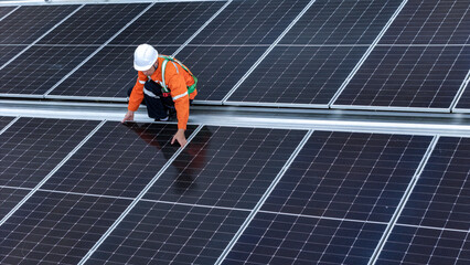 Solar power technician inspecting rooftop solar panels, performing maintenance and installation of...