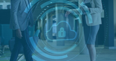 Displaying digital cloud lock graphic over modern office corridor, with colleagues walking past
