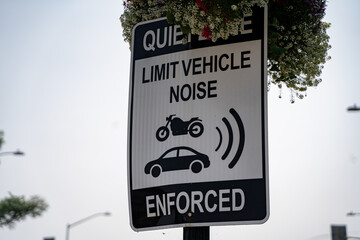 View of limit vehicle noise enforced sign on roadside.