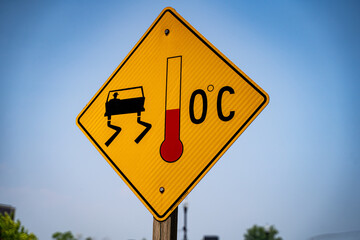 View of yellow slippery floor warning sign showing 0 degree on roadside.