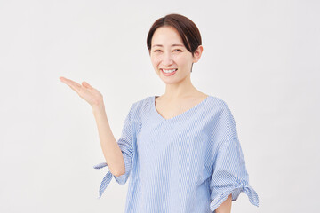 女性　ミドルエイジ　手のひらで左を指す　白背景