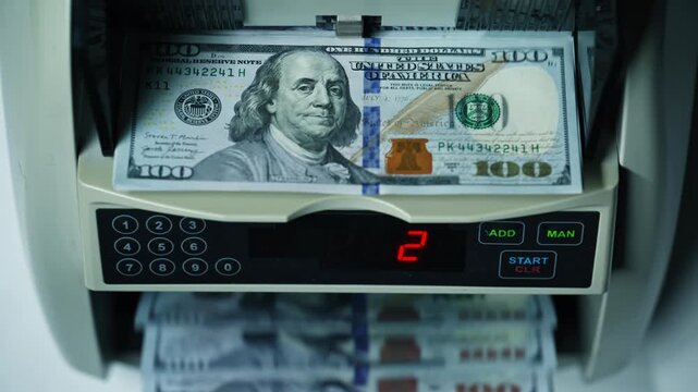Automatic machine counting dollar bills money denomination of hundred closeup