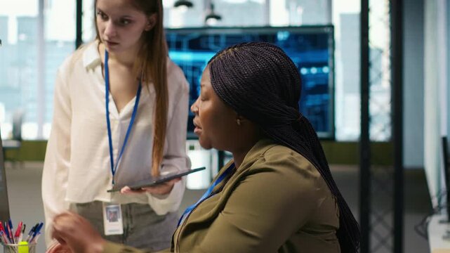 Manager teaching young technician how to develop software and optimize code using AI. Team leader guiding intern in office on how to use artificial intelligence to resolve bottlenecks, camera A