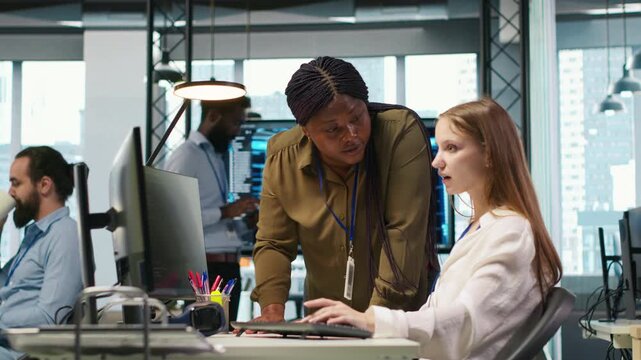 Manager supervising young trainee in office using AI technology, monitoring performance dashboards. Team leader overseeing work done by junior dev tuning neural networks using tools on PC, camera A