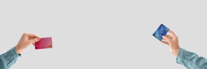 Hands holding credit cards on light background with space for text