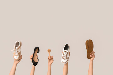 Female hands with stylish shoes, insoles and brush on white background. Shoe repair concept